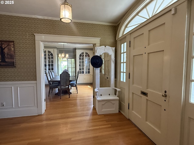 880 E 2nd St, Coquille, OR 97423 - foyer with wallpapered walls, a chandelier, a wainscoted wall, light wood-style floors, and crown molding