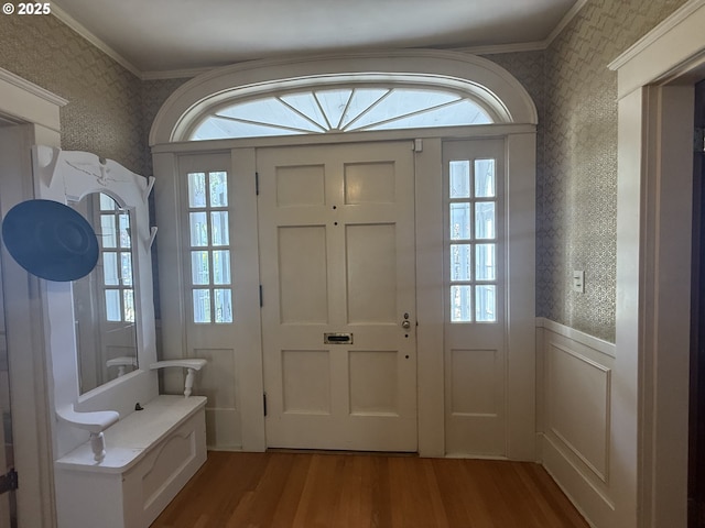 880 E 2nd St, Coquille, OR 97423 - foyer entrance with wallpapered walls, wood finished floors, crown molding, a wainscoted wall, and plenty of natural light