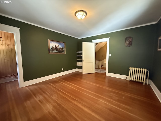 880 E 2nd St, Coquille, OR 97423 - spare room featuring radiator heating unit, ornamental molding, wood finished floors, and stairs