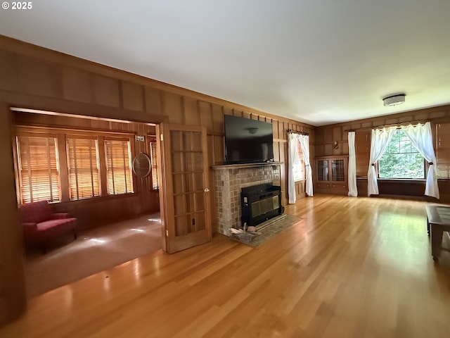 880 E 2nd St, Coquille, OR 97423 - unfurnished living room featuring a fireplace, light wood-style flooring, and wood walls