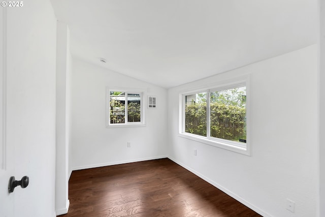 empty room with baseboards, dark wood-style flooring, and lofted ceiling