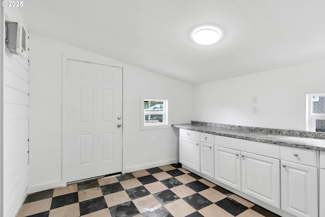 laundry area with light floors, plenty of natural light, and baseboards