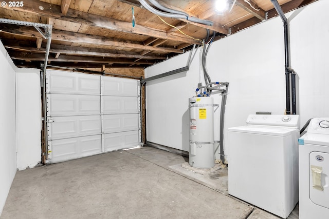 garage featuring washing machine and clothes dryer and strapped water heater