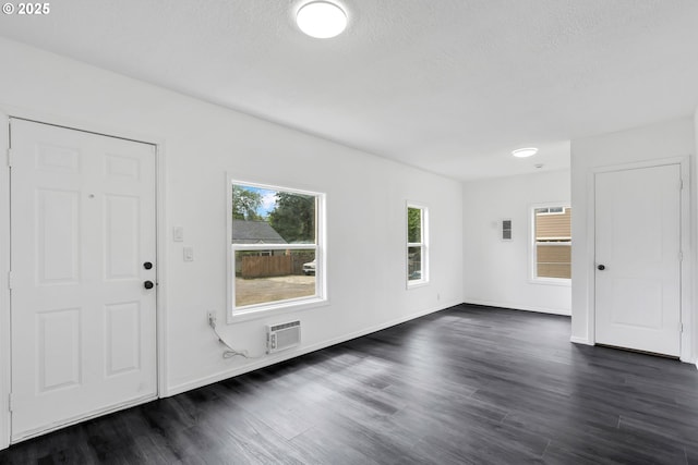 foyer entrance featuring a textured ceiling, dark wood-style floors, and baseboards