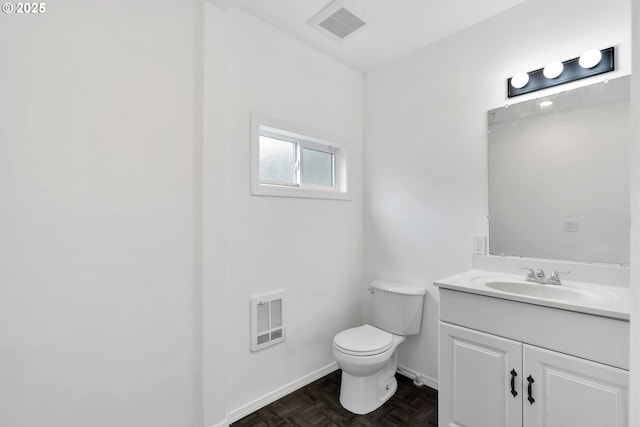 half bathroom featuring toilet, baseboards, visible vents, and vanity