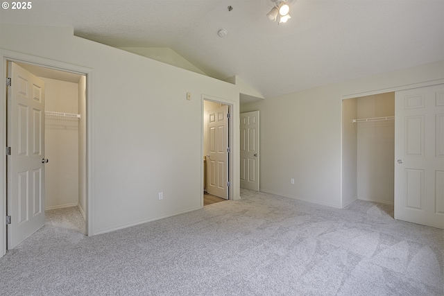 1115 NE 86th Way, Hillsboro, OR 97006 - unfurnished bedroom featuring a walk in closet, a closet, carpet, and lofted ceiling