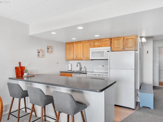 1146 N Marion Ave Unit 628, Gearhart, OR 97138 - kitchen with white appliances, dark countertops, a kitchen breakfast bar, a peninsula, and recessed lighting