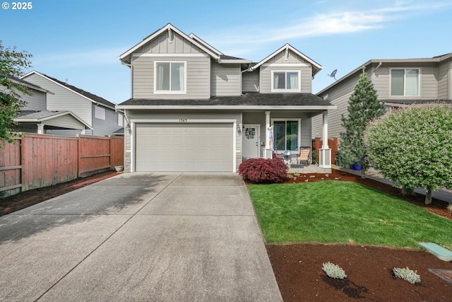 view of front of home with fence, an attached garage, a front lawn, board and batten siding, and concrete driveway