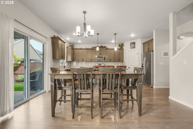 dining space featuring recessed lighting, baseboards, an inviting chandelier, and light wood-style flooring
