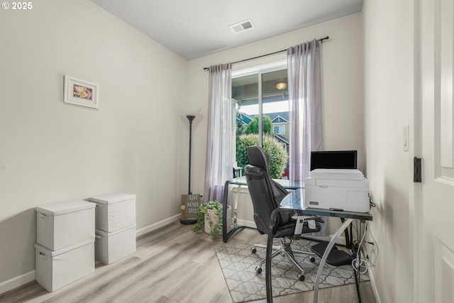office space featuring baseboards, visible vents, and light wood-style floors