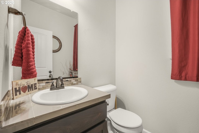 half bathroom with toilet, decorative backsplash, and vanity