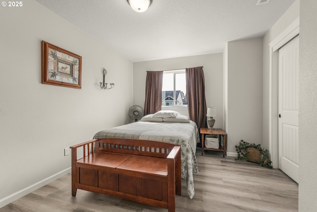 bedroom with baseboards and wood finished floors