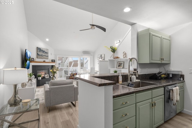 kitchen featuring stainless steel dishwasher, light wood-style floors, a sink, and green cabinets