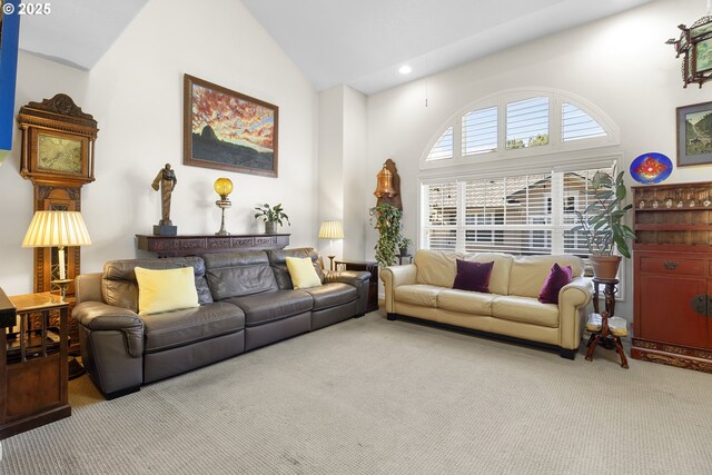 carpeted living room featuring high vaulted ceiling