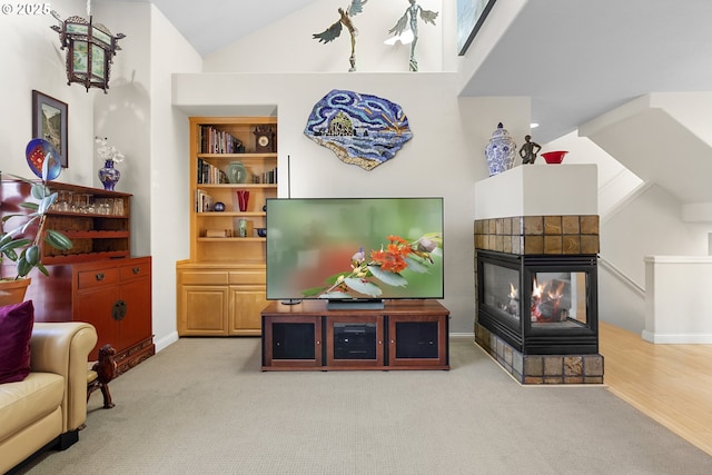 living room with a fireplace, light carpet, high vaulted ceiling, and built in features