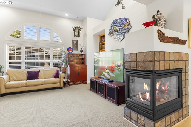 living room with high vaulted ceiling, a tiled fireplace, carpet floors, and built in shelves