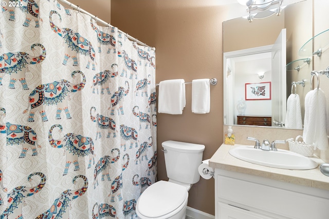 bathroom featuring toilet, curtained shower, and vanity