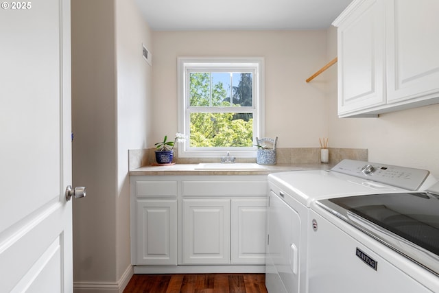 washroom with independent washer and dryer, dark wood-type flooring, cabinets, and sink