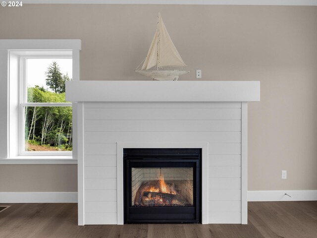 1790 Thompson Falls Dr, Seaside, OR 97138 - detailed view of a warm lit fireplace and wood finished floors