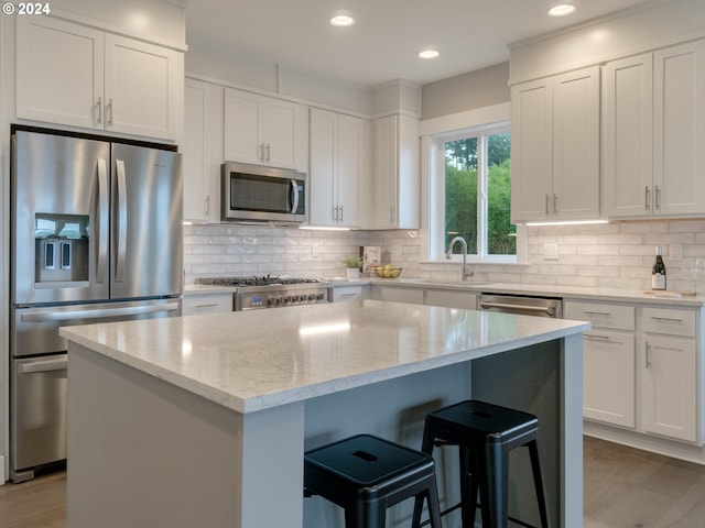 1790 Thompson Falls Dr, Seaside, OR 97138 - kitchen featuring appliances with stainless steel finishes, a center island, a breakfast bar area, white cabinets, and recessed lighting