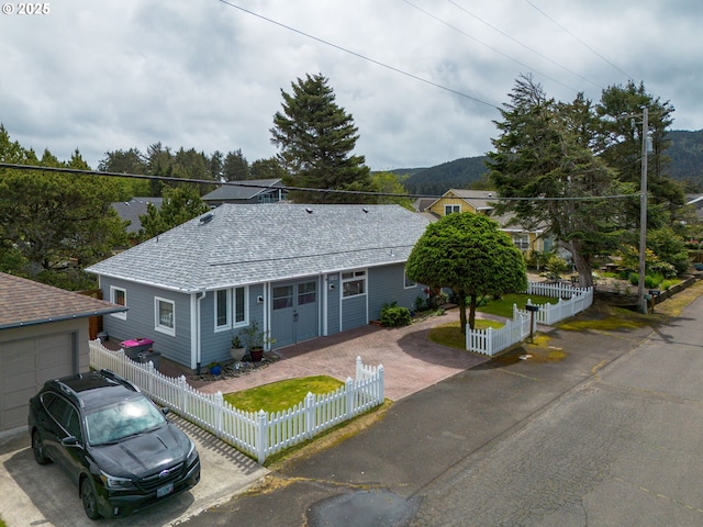 2385 S Downing St, Seaside, OR 97138 - ranch-style house with driveway, a fenced front yard, roof with shingles, a mountain view, and a garage
