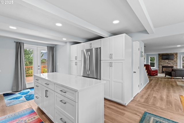 2385 S Downing St, Seaside, OR 97138 - kitchen featuring freestanding refrigerator, beamed ceiling, light wood-style floors, open floor plan, and white cabinetry