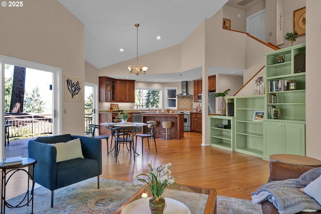 living room featuring light wood-style floors, a chandelier, high vaulted ceiling, and recessed lighting