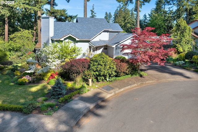 view of front of house with a chimney and a shingled roof