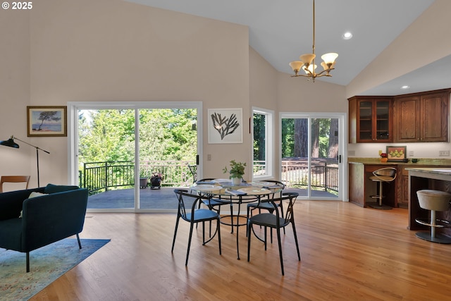 dining room with high vaulted ceiling, a chandelier, light wood-style floors, and recessed lighting