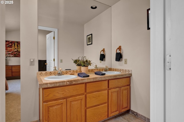 full bathroom featuring double vanity, baseboards, and ensuite bath