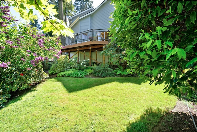 view of green lawn featuring a wooden deck