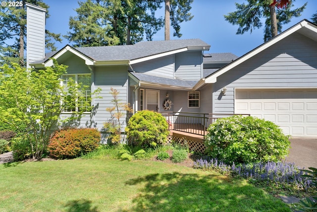 view of front of home with a front lawn, an attached garage, a chimney, and roof with shingles