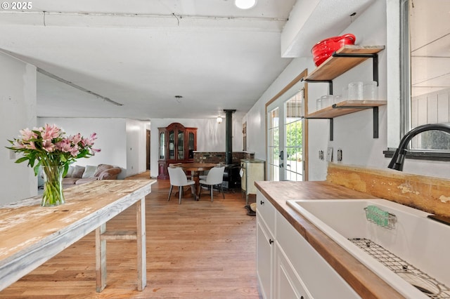 22224 S Kamrath Rd, Oregon City, OR 97045 - kitchen with open shelves, white cabinets, light wood-style floors, french doors, and a wood stove