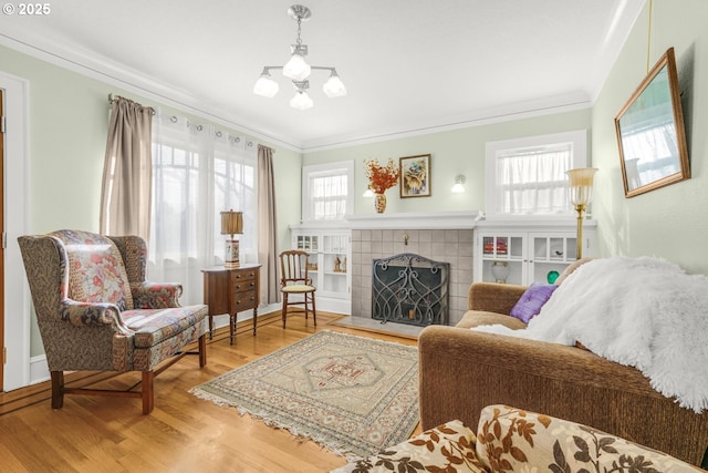 living room featuring a wealth of natural light, a fireplace, wood finished floors, and crown molding