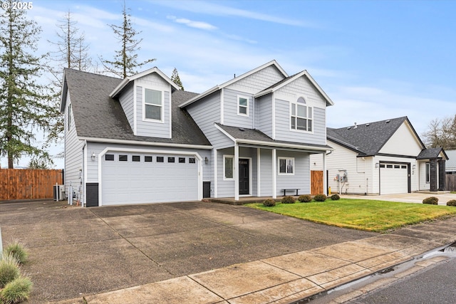 view of front facade featuring fence, roof with shingles, an attached garage, concrete driveway, and a front lawn