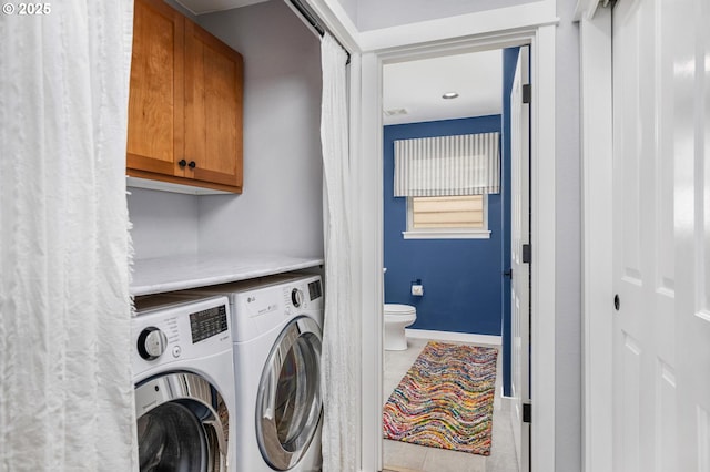 laundry room with baseboards, washer and clothes dryer, light tile patterned floors, and cabinet space