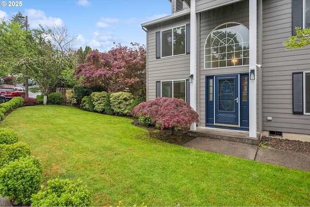 entrance to property with a lawn