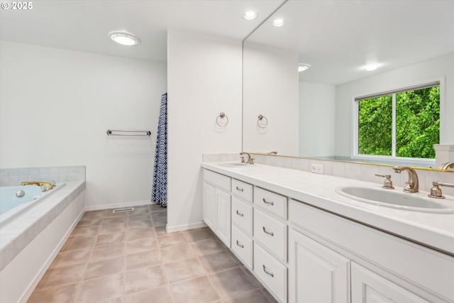 bathroom with double vanity, a tub, baseboards, and recessed lighting