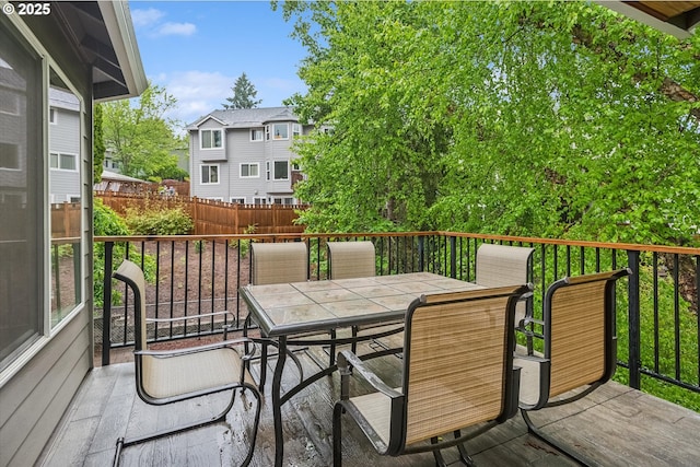 wooden terrace featuring outdoor dining space and fence