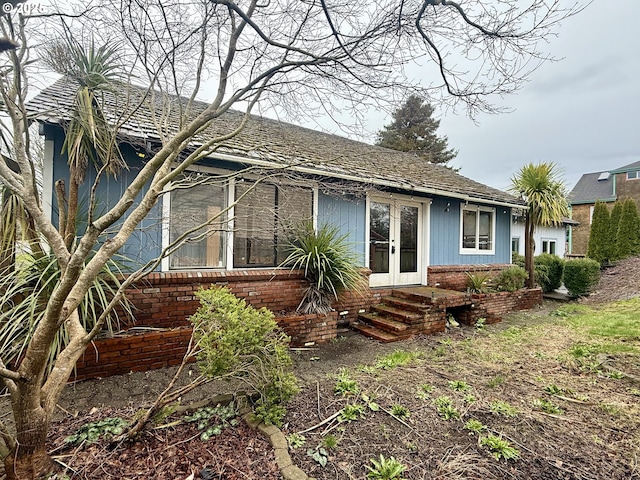 back of property featuring french doors and brick siding