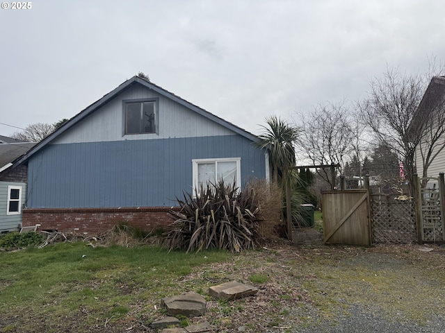 view of property exterior with fence and brick siding