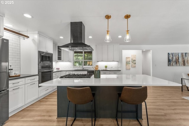 4992 Prospect St, West Linn, OR 97068 - kitchen with stainless steel appliances, island exhaust hood, tasteful backsplash, a kitchen bar, and recessed lighting