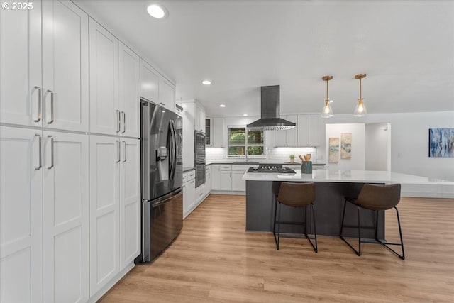 4992 Prospect St, West Linn, OR 97068 - kitchen with stainless steel appliances, island range hood, white cabinetry, a breakfast bar area, and recessed lighting