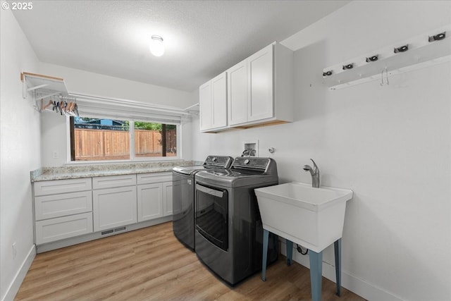 4992 Prospect St, West Linn, OR 97068 - washroom with washing machine and clothes dryer, cabinet space, light wood-style floors, and a textured ceiling
