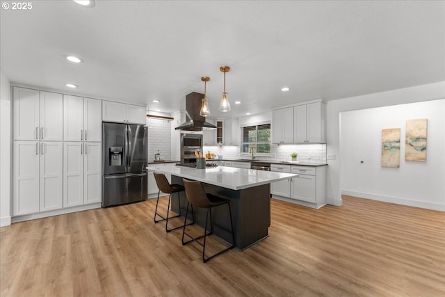 4992 Prospect St, West Linn, OR 97068 - kitchen with stainless steel appliances, island range hood, decorative backsplash, light wood-style floors, and a breakfast bar