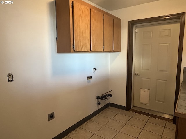 laundry area featuring light tile patterned floors, baseboards, cabinet space, and electric dryer hookup