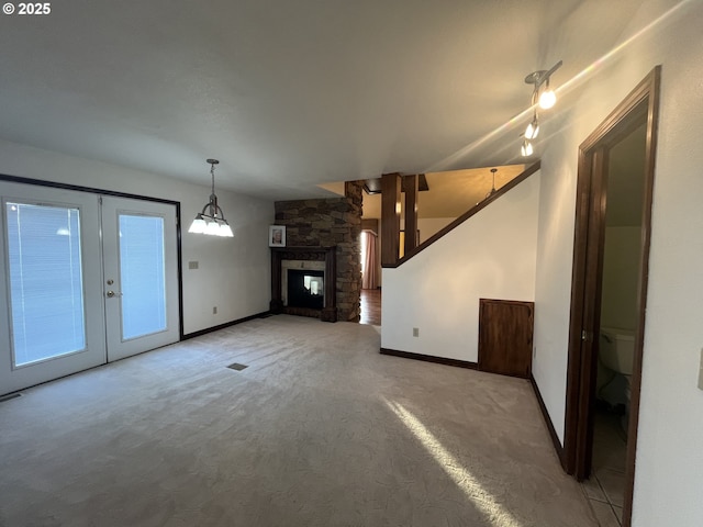 unfurnished living room featuring french doors, baseboards, and light carpet