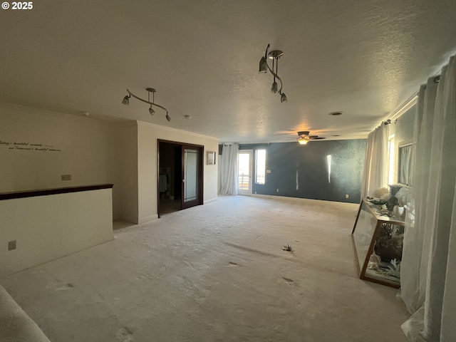 unfurnished room with light carpet, ceiling fan, and a textured ceiling