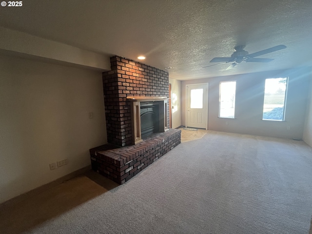 unfurnished living room with light colored carpet, a fireplace, and a textured ceiling