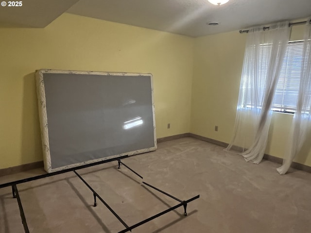 spare room featuring carpet flooring and baseboards